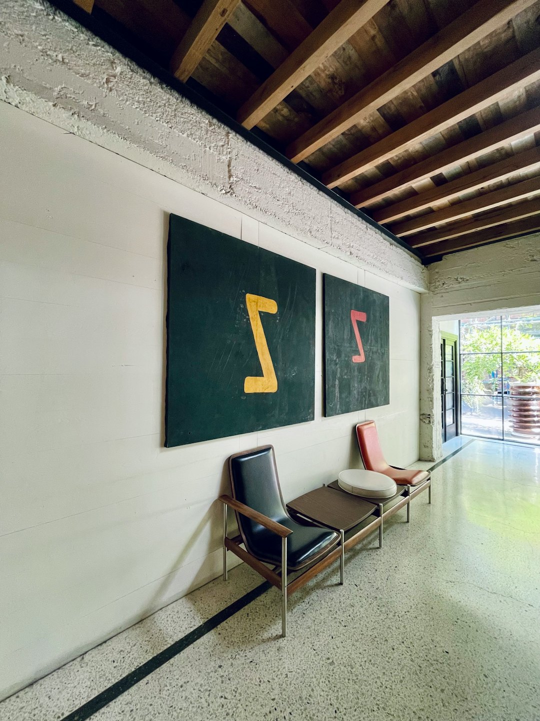 Waiting area with chairs and abstract art in a modern office.